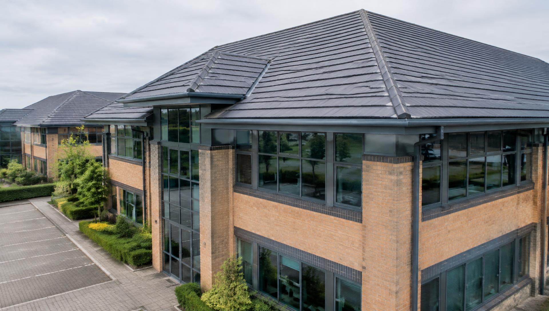 Commercial office building with a clean tiled roof and gutters